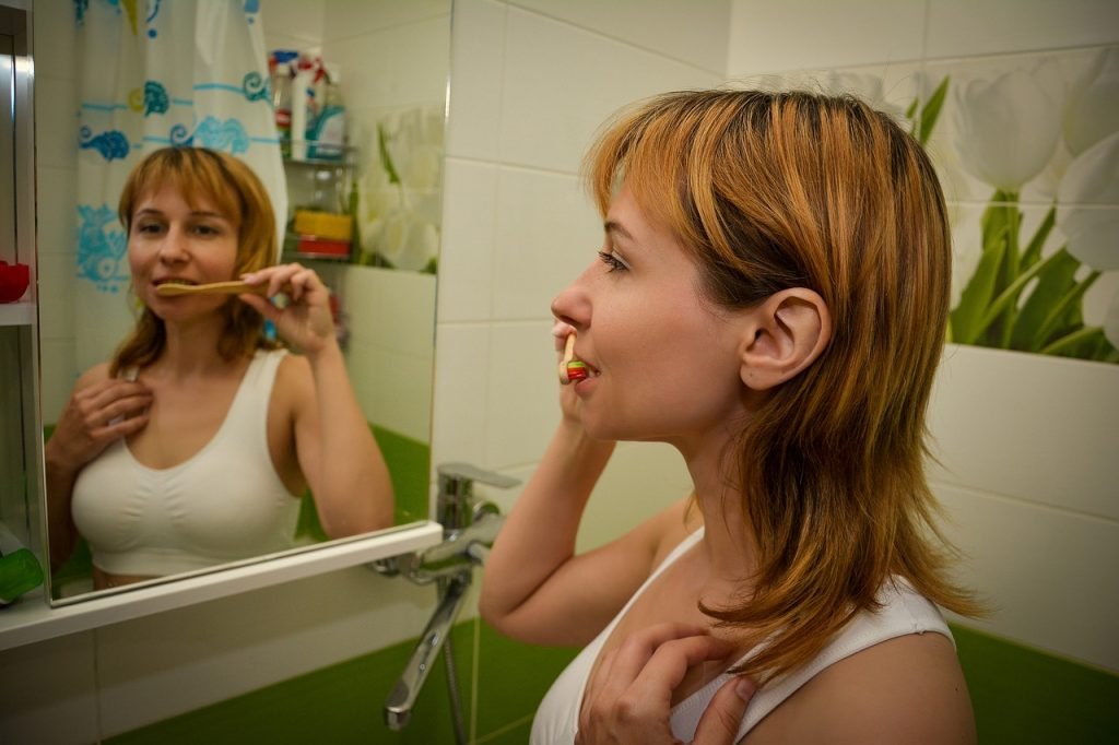 Mujer joven cepillandose con un correcto cepillado de dientes
